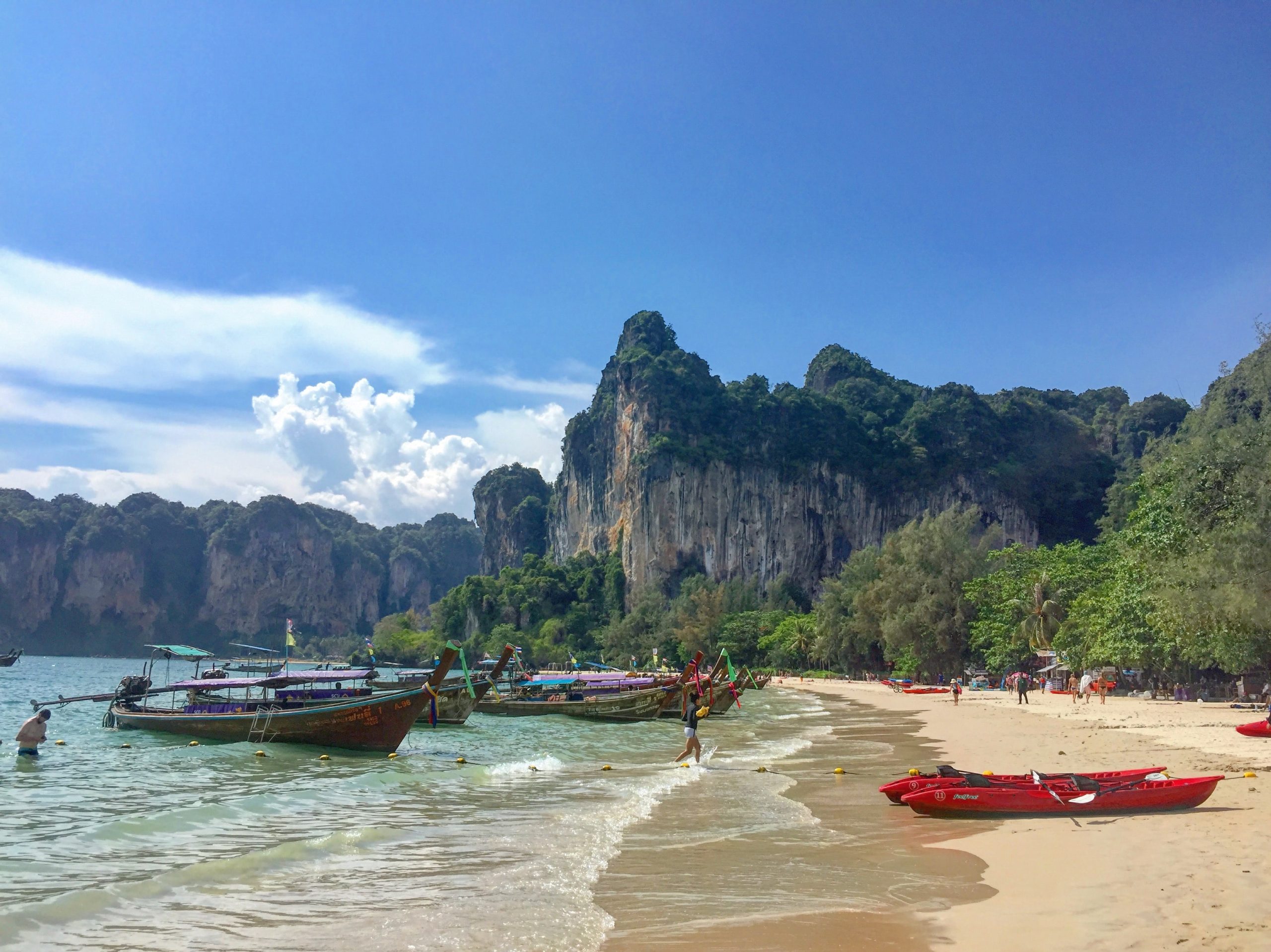 Sandstrand med båtar i Thailand