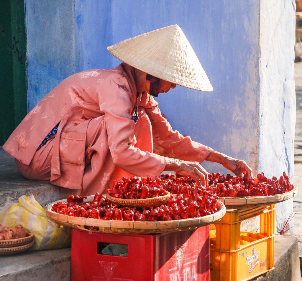 Vietnamese street vendor sell small ceramic statues