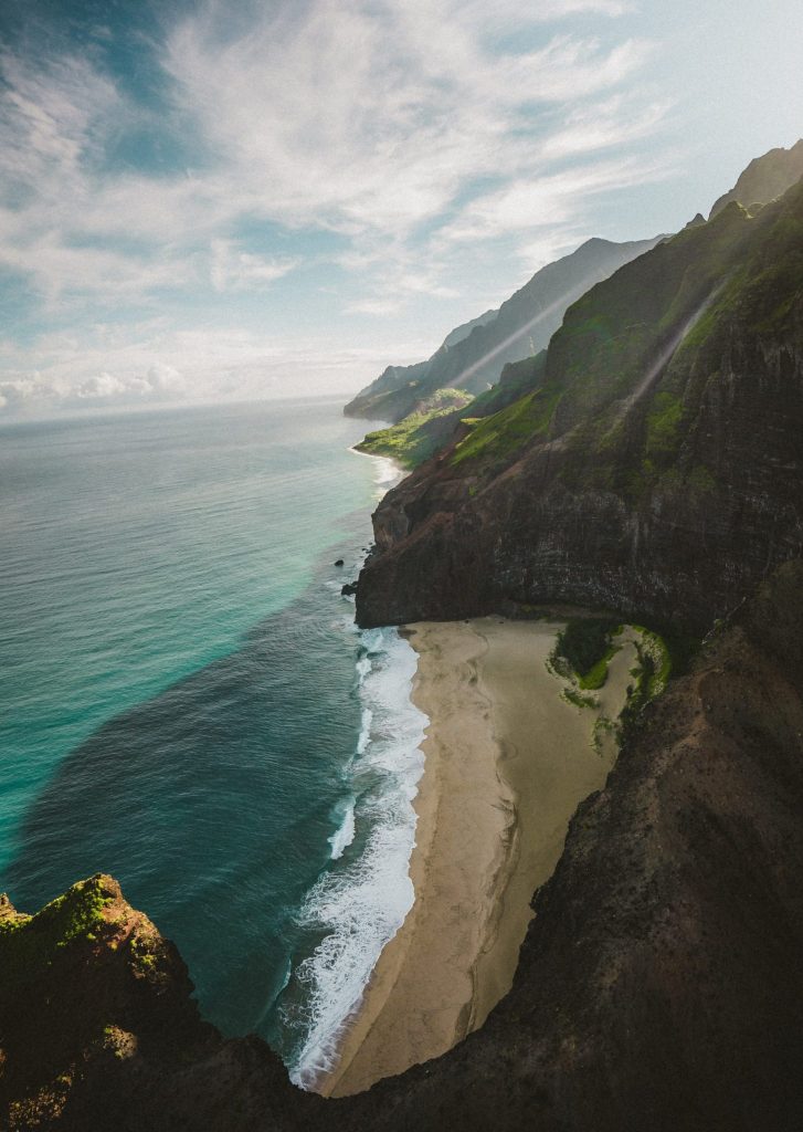 Kauaiöns kust med blått vatten och höga berg