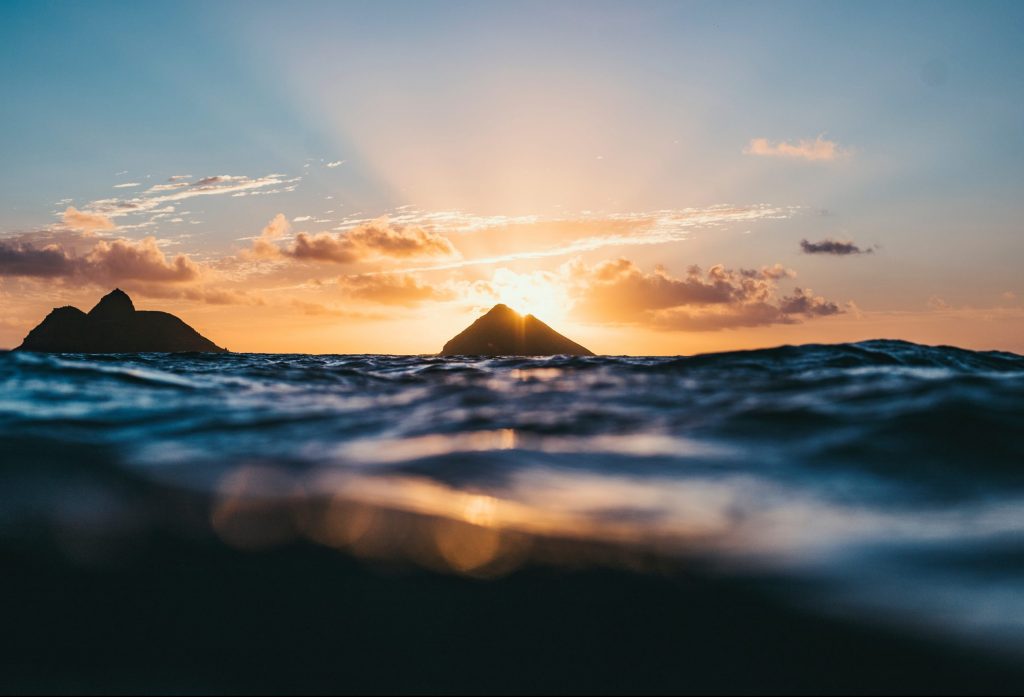 Oahu ön med solnedgång bakom bergen med havet i närbild