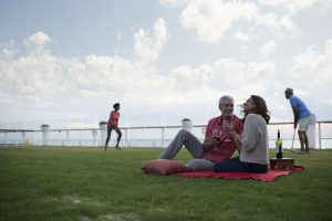 Picknick på grön gräsmatta omborrd Celebrity Equinox