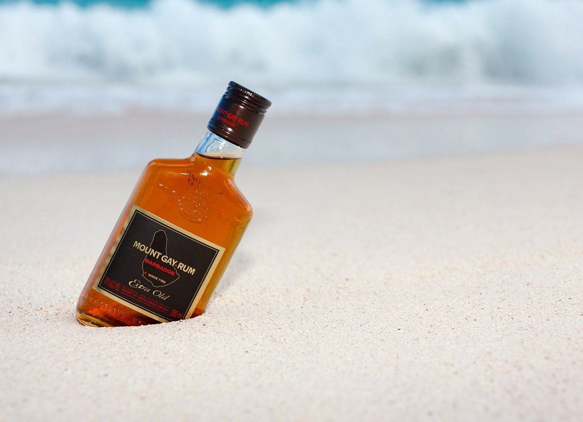 En flaska Mount Gay rom på strand i Barbado